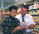 grocer and customer examining box of food 