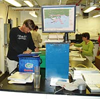 image of scientists examining data in the on-board lab