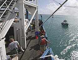 image of side of ship with people on deck