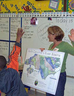 image of author holding a large map in a classron