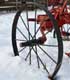 The wheel of a red antique push tractor. [Source: IStock International, Inc.]