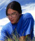 A Young Native American Man Looks Closely at Field Grasses