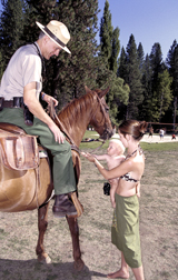 Park Ranger on horse patrol greeting park visitors.