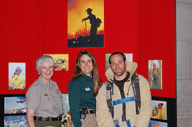 group shot of Barb Stewart, Traci Weaver, and Kurt Atkins in front of a display for the event