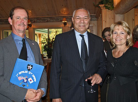 Steve Semancik and his wife, Debi, standing on either side of retired Gen. Colin Powell. Semancik is holding his yearbook.