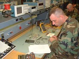 Photo of Soldier reading a diagram and building a circuit
