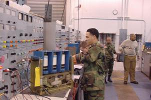 Photo of Soldiers performing maintenance and testing the operation of the vacuum contractor