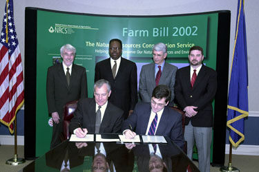 Sitting L to R - Dr. Jack Britt, vice president, Institute of Agriculture, University of Tennessee (UT), and Bruce Knight, NRCS chief, sign copies of a memorandum of understanding between UT and USDA. Folks in back row are identified below.