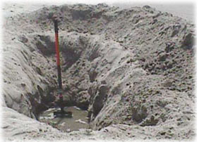 Picture of a hole dug at the beach, showing standing water at the bottom of the hole. Very similar to the top of the water table. 