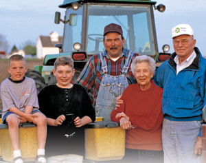 A farm family posing near a tractor. 