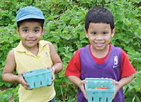 Children holding strawberries.