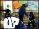 Secretary Paige assists a struggling reader in the library of the Savoonga village school.