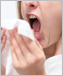 Photo of a young woman sneezing.