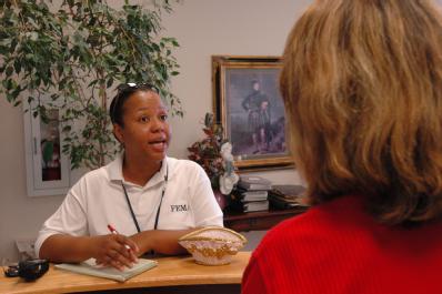 Saraland, AL, July 18, 2005 -- FEMA Comunity Relations (CR) officer Casi Davis (facing) speaks with Saraland Chamber of Commerce Director Pamela Burnham. The CR officers take information about the FEMA recovery process directly to the residents affected by Hurricane Dennis.   FEMA Photo/Mark Wolfe