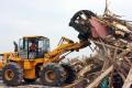 A an operator uses a front end loader move a pile of debris in Texas