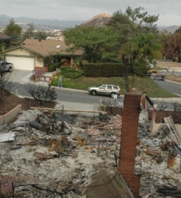 The Peters' home shown across the street from a neighboring home destroyed by the fire.