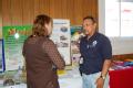 FEMA mitigation worker speaks to a resident at a County Fair in Iowa