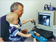 Ken Nixon and his grandson talk with Ken’s mother, shown on a computer monitor