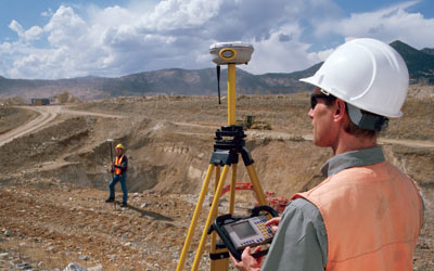 Two surveyors at an open pit mining site