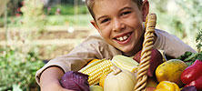 A boy holding a basket of vegetables