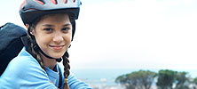 A girl wearing a helmet sitting on a bicycle