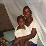 Photo: A mother and child sitting under a mosquito net