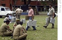 Polling officers check carry electric voting machines to be used in the first phase of elections, as security personnel look on in Jammu, India, Wednesday, 15 April 2009