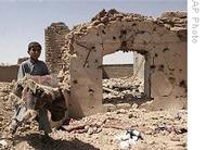 A boy carries his belongings next to the rubble of his home which was destroyed in a US airstrike in the village of Azizabad in Shindand district of Herat province, Afghanistan, 23 Aug 2008