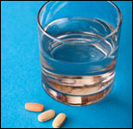 Photo: A glass of water and pills