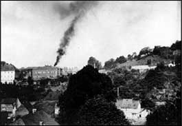 Smoke rising from the chimney at Hadamar, one of six facilities which carried out the Nazis' Euthanasia Program. Hadamar, Germany, probably 1941.