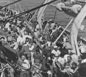 Refugees crowd the deck of a U.S. army transport carrying nearly 1,000 Jews from Europe to the United States. The refugees will be sheltered at Fort Ontario near Oswego, New York. Atlantic Ocean, August 1944.