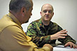Air Force Maj. Matthew Conlan talks with co-worker Mike Bernard at the Air Force's counter-improvised explosive device office in Arlington, Va. Conlan was seriously injured in Afghanistan in 2005 by a booby-trapped piece of unexploded ordnance. DoD photo by Fred W. Baker III