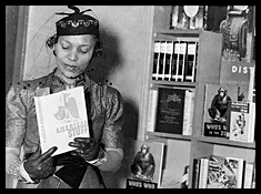 Zora Neale Hurston holding the book "American Stuff", standing next to a bookshelf