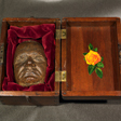 Open wooden box with a life mask on the left side.