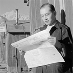 Roy Takeno reading paper in front of office