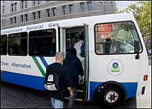 Photo: passengers boarding bus that  says "Natural Gas " on the side.