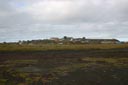 St. Paul Village hill rises up in the distance, with houses, the church, and community buildings visible