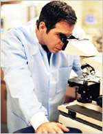 Photo of scientist looking into microscope