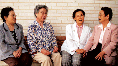 Four Asian women talking and laughing