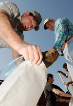 Members of the community band together to fill sandbags for an operation going on near a levee in an area called Sandhill. Jocelyn Augustino/FEMA