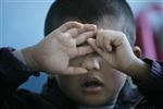 An autistic child reacts during a therapy session at the Stars and Rain School for autistic children in Beijing March 23, 2009. REUTERS/Jason Lee
