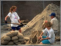 Photo of people filling sand bags.