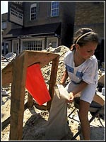 Photo of a little girl filling sand bags.