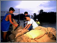 Photo of boys stacking sand bags.