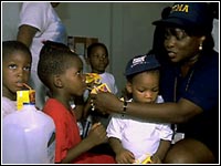 Photo of a FEMA employee giving children juice boxes.