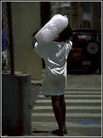 Photo of a child carrying a sand bag.