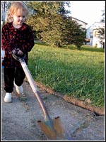 Photo of a girl carrying a shovel.