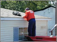 Photo of a rescuer rescuing a dog off a roof.