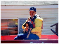 Photo of a rescuer carrying a dog.