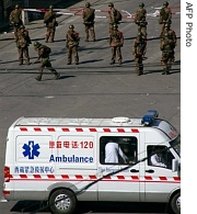 An ambulance drives by Chinese soldiers on a street in the Tibetan capital Lhasa a day after violent protests broke out, 15 Mar 2008